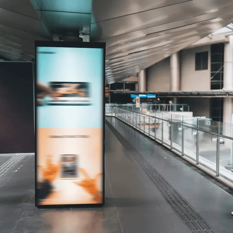 Freestanding indoor digital signage display in a modern school corridor, designed to share dynamic messages, events, and school updates.